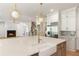 Open concept kitchen with a large island, farmhouse sink, stainless steel appliances and a view into the living room at 117 Owens Mill Pl, Canton, GA 30115