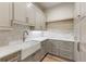 Bright kitchen features a farmhouse sink, white countertops, and gray cabinetry at 117 Owens Mill Pl, Canton, GA 30115