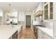 Bright kitchen featuring a stainless steel range, custom hood, island with farm sink and quartz countertops at 117 Owens Mill Pl, Canton, GA 30115