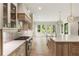 Modern gourmet kitchen with custom cabinetry, stainless range and hood, an island with bar seating, and rear yard views at 117 Owens Mill Pl, Canton, GA 30115