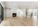 Bright living room featuring fireplace, light wood floors, and staircase with black metal handrail at 117 Owens Mill Pl, Canton, GA 30115