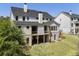 Rear exterior view of a two-story home with a deck, patio, lush lawn, and mature trees at 117 Owens Mill Pl, Canton, GA 30115