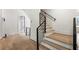 Modern staircase featuring wood treads, sleek black railing, and ample natural light from the window at 117 Owens Mill Pl, Canton, GA 30115