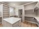 Bright walk-in closet with custom storage, island, and built-in shelving for optimal organization at 117 Owens Mill Pl, Canton, GA 30115