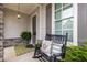 Cozy front porch with a rocking chair, decorative pillows, and charming stone accents at 2004 Haley Walk, Woodstock, GA 30188