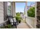 Inviting front porch with a classic rocking chair, potted plants, and a picturesque neighborhood view at 2004 Haley Walk, Woodstock, GA 30188