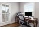 Well-lit home office with desk, modern computer, and an adjacent door to a small outdoor space at 2004 Haley Walk, Woodstock, GA 30188