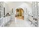 A large bathroom featuring dual vanities with white cabinets, and a large arched opening at 700 Winterwind Way, Roswell, GA 30075