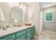 Charming bathroom featuring a teal vanity, granite countertop, and brushed gold fixtures at 700 Winterwind Way, Roswell, GA 30075