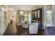 Spacious hallway featuring hardwood floors, contemporary lighting, and a bar with a large china cabinet at 700 Winterwind Way, Roswell, GA 30075