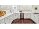 A modern kitchen with white cabinetry, stainless steel appliances, and beautiful wood flooring at 700 Winterwind Way, Roswell, GA 30075