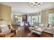 Spacious living room featuring hardwood floors and large windows overlooking the outdoor landscape at 700 Winterwind Way, Roswell, GA 30075