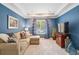 A comfortable living room featuring a large sofa, a TV, and bright blue walls at 700 Winterwind Way, Roswell, GA 30075