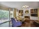 Bright living room featuring hardwood floors, a fireplace, built-in bookshelves and large windows overlooking the yard at 700 Winterwind Way, Roswell, GA 30075
