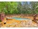Private pool with beautiful stone patio and mature trees for shade and relaxation at 700 Winterwind Way, Roswell, GA 30075