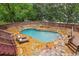 Inviting backyard pool with a stone patio and surrounding lush landscaping at 700 Winterwind Way, Roswell, GA 30075
