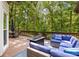 Outdoor deck featuring comfortable seating, a fire pit, and views of a wooded backyard at 2355 Twelvestones Dr, Roswell, GA 30076