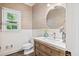 Elegant powder room featuring a stylish round mirror and a wooden vanity with a white countertop at 2355 Twelvestones Dr, Roswell, GA 30076