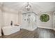 Spa bathroom with a standalone tub and glass enclosed shower accented with a round window at 2355 Twelvestones Dr, Roswell, GA 30076