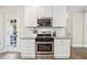Modern kitchen featuring stainless steel appliances, white cabinets, and granite countertops at 2355 Twelvestones Dr, Roswell, GA 30076