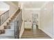 Hallway with wood-look floors leading to a staircase and view to a living space at 2355 Twelvestones Dr, Roswell, GA 30076