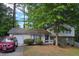 Charming two-story home with a well-maintained lawn, mature trees, and a visible garage at 6193 Charring Cross Ct, Lithonia, GA 30058