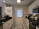 Efficient kitchen with white cabinets, black countertops, and stainless steel appliances and marble tile floor at 6193 Charring Cross Ct, Lithonia, GA 30058