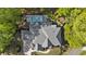 Aerial view of a stunning house with manicured lawn and pool with umbrellas surrounded by mature trees at 214 Kenneth Drive, Alpharetta, GA 30009