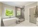 Modern bathroom featuring a soaking tub, walk-in shower, and natural light at 214 Kenneth Drive, Alpharetta, GA 30009