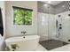 Bathroom showcasing a freestanding tub, glass shower with black fixtures, and geometric accent tiling at 214 Kenneth Drive, Alpharetta, GA 30009