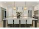 Bright kitchen features a large island with seating, decorative lighting, and stainless steel appliances at 214 Kenneth Drive, Alpharetta, GA 30009