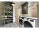 Laundry room with modern washer and dryer, storage cabinets, and stylish black and white patterned floors at 214 Kenneth Drive, Alpharetta, GA 30009