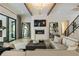 Spacious living room featuring exposed beams, a fireplace, a modern staircase, and comfortable seating at 214 Kenneth Drive, Alpharetta, GA 30009
