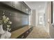 Mud room with a bench, coat hooks, storage cabinets, and herringbone-patterned brick floors at 214 Kenneth Drive, Alpharetta, GA 30009