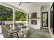 Covered outdoor patio with a fireplace, comfortable seating, and view of landscaped backyard at 214 Kenneth Drive, Alpharetta, GA 30009