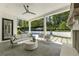 Covered patio area with ceiling fan, stone floors, outdoor seating, and a fireplace overlooking the pool at 214 Kenneth Drive, Alpharetta, GA 30009