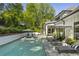 Inviting pool with lounge chairs and umbrellas, surrounded by lush landscaping and a white brick retaining wall at 214 Kenneth Drive, Alpharetta, GA 30009