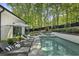 Outdoor pool area with stylish lounge chairs and a peaceful backyard setting at 214 Kenneth Drive, Alpharetta, GA 30009