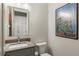 Stylish powder room features modern fixtures, unique artwork, and a neutral color palette at 214 Kenneth Drive, Alpharetta, GA 30009