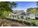 Stunning rear exterior features a covered patio, pool with lounging area, and lush landscaping for serene outdoor living at 214 Kenneth Drive, Alpharetta, GA 30009