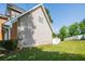 Side view of backyard with white fence, lush green grass, and a glimpse of the house with brick and vinyl siding at 2253 Carrington Dr, Ellenwood, GA 30294
