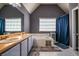 Bathroom featuring a double sink vanity, soaking tub, a window, and a gray accent wall at 2253 Carrington Dr, Ellenwood, GA 30294