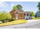 Traditional brick home with manicured front lawn, two cars parked in the driveway on a sunny day at 2253 Carrington Dr, Ellenwood, GA 30294