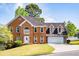 Traditional brick home with well-maintained landscaping, attached garage, and bright white trim against a vivid blue sky at 2253 Carrington Dr, Ellenwood, GA 30294