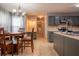Bright kitchen features an island, gray cabinetry, tile floors, adjacent desk, and pendant lighting at 2253 Carrington Dr, Ellenwood, GA 30294