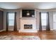 Living room featuring a painted brick fireplace with TV, hardwood floors, and lots of light at 2253 Carrington Dr, Ellenwood, GA 30294