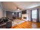 Bright living room with a painted brick fireplace, large rug, and hardwood floors at 2253 Carrington Dr, Ellenwood, GA 30294