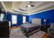Main bedroom featuring tray ceilings, ceiling fan, wood flooring, and comfortable seating at 2253 Carrington Dr, Ellenwood, GA 30294