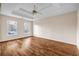 A bright main bedroom features a trey ceiling, ceiling fan, hardwood floor, and large windows at 1600 Dillwood Ct, Lithonia, GA 30058