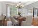 Elegant dining room with hardwood floors, modern chandelier, and a large window bringing in natural light at 2660 Brentwood Estates Ct, Cumming, GA 30041
